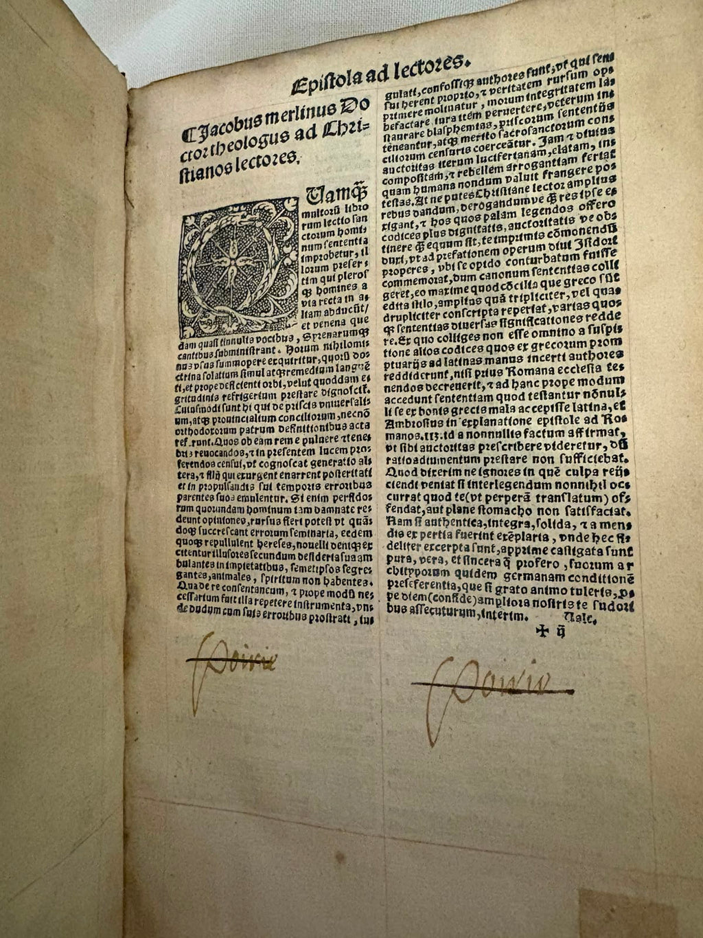The Epistola ad lectores leaf, printed in two columns of Gothic black letter with a large decorative woodcut initial. At the foot of the page are two early manuscript ownership inscriptions in brown ink, each struck through with a single stroke of the pen.